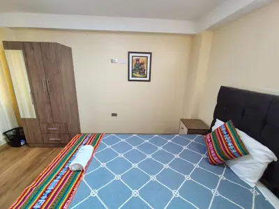 a bedroom with a bed with a blue comforter at Departamento en La casa de Teresita in Cusco