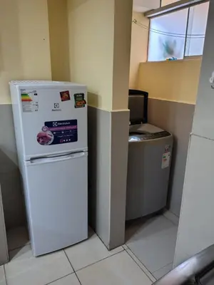 a refrigerator and a trash can in a room at Departamento en La casa de Teresita in Cusco