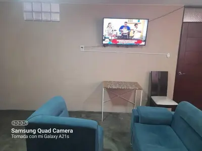 a living room with two blue chairs and a flat screen tv at 201 Comfy Apt WiFi kitchen SmartTV Central at Callao in Lima