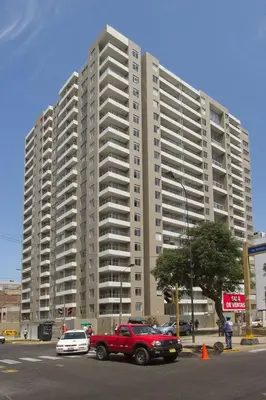 a red truck parked in front of a large building at Private Apartament in LINCE near MIRAFLORES & REBAGLIATI HOSPITAL with POOL, GYM, PRIVATE PARK ! in Lima