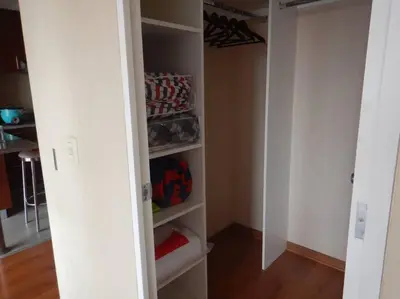 a walk in closet with white walls and shelves at Private Apartament in LINCE near MIRAFLORES & REBAGLIATI HOSPITAL with POOL, GYM, PRIVATE PARK ! in Lima