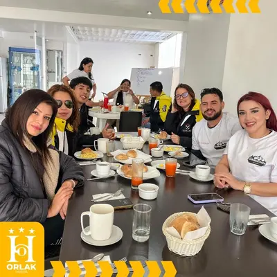 a group of people sitting around a table eating food at Hotel Orlak in Huancayo