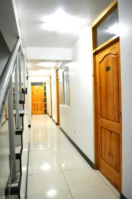a hallway with stairs and a wooden door at Hotel Orlak in Huancayo