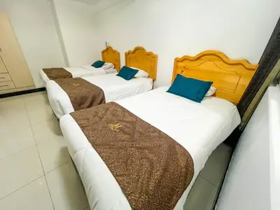 a group of three beds in a room at Hotel Orlak in Huancayo