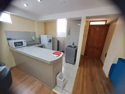 a small kitchen with a counter and a refrigerator at Departamento INTI - casa de Teresita in Cusco