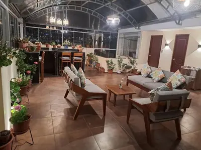 a living room with couches and tables and potted plants at Departamento INTI - casa de Teresita in Cusco