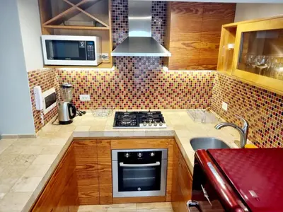 a small kitchen with a stove and a microwave at E SuiteTOP Tudela San Isidro Lima 2B 202 in Lima