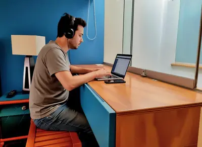 a man sitting at a desk with a laptop computer at E SuiteTOP Tudela San Isidro Lima 2B 202 in Lima