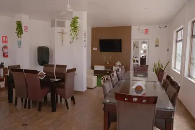 a living room with a dining table and chairs at Hotel San Martín in San Juan de Marcona