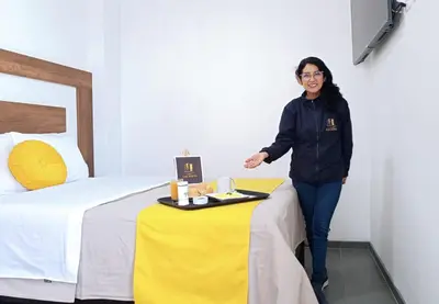 a woman standing next to a table in a hotel room at Hotel San Martín in San Juan de Marcona
