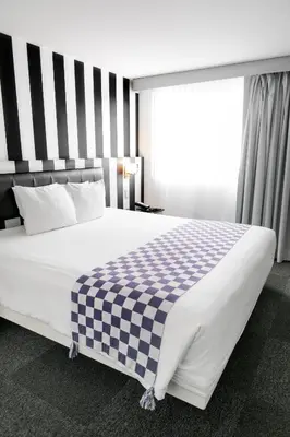 a large bed with a checkered blanket on it at Wyndham Costa del Sol Lima City in Lima