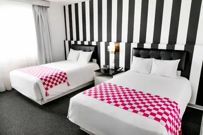 a hotel room with two beds with red and white sheets at Wyndham Costa del Sol Lima City in Lima