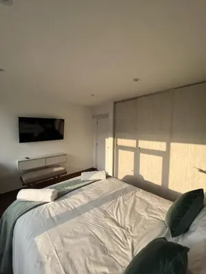 a bedroom with a large bed with a tv on the wall at Wonderful apartment Miraflores Kennedy 603A in Lima