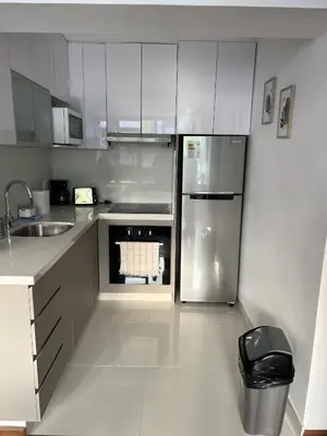 a kitchen with white cabinets and a stainless steel refrigerator at Wonderful apartment Miraflores Kennedy 603A in Lima