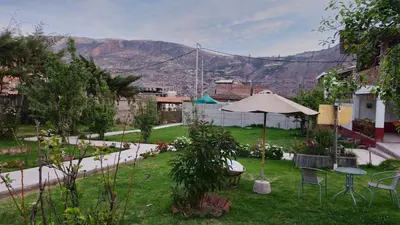 a garden with a table and an umbrella at Chaska Valle Green in Urubamba