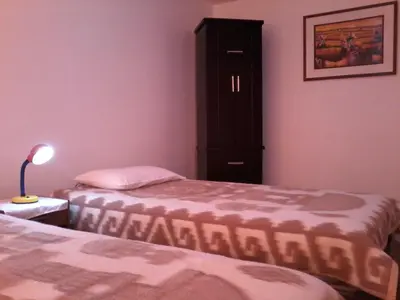 a bedroom with two beds and a cabinet at Royal Sweet Dreams Airport B&B in Lima
