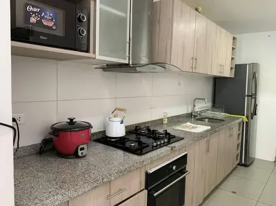 a kitchen with a stove top and a refrigerator at Departamento de 04 dormitorios in Lima