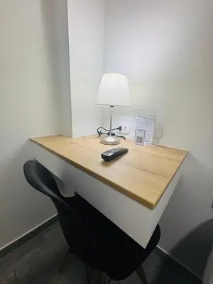 a desk with a lamp and a remote control on it at Costanera Hotel in Minas de Marcona
