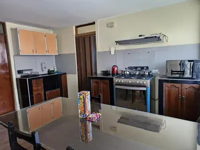 a kitchen with a table and a stove top oven at Apartamento-Santa Anita, Villa Caly in Lima
