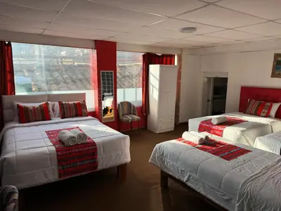 a hotel room with two beds and a window at Hotel Plateros in Cusco