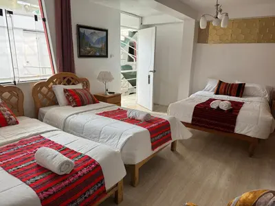 a bedroom with two beds and a window at Hotel Plateros in Cusco