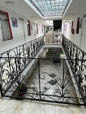 a staircase in a building with a wrought iron railing at Hotel Plateros in Cusco