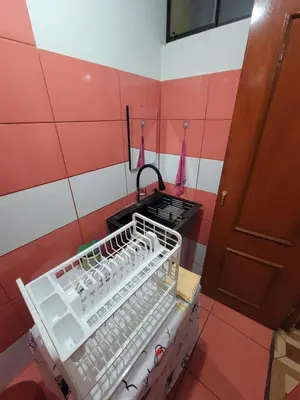 a kitchen with a stove and a basket of water bottles at Departamento, LUJO HOGAR cerca a PLAZA NORTE - UNI AEROPUERTO in Lima