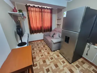 a living room with a refrigerator and a couch at Departamento, LUJO HOGAR cerca a PLAZA NORTE - UNI AEROPUERTO in Lima