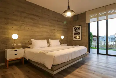 a bedroom with a large bed with a wooden wall at Aldea 3BR Chic Bay Hideaway in Paracas