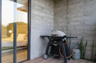 a barbecue grill in a room with a bedroom at Aldea 3BR Chic Bay Hideaway in Paracas