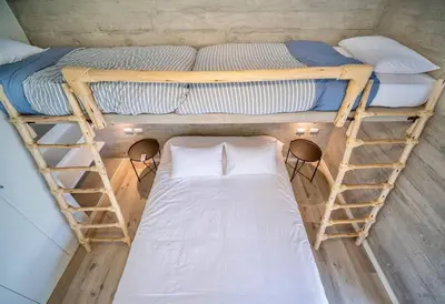 a small room with two bunk beds in it at 2BR Spacious Ground Level with Gym Pool and Cowork in Paracas