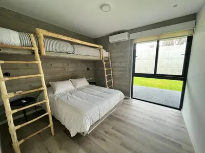 a bedroom with two bunk beds and a window at 2BR Spacious Ground Level with Gym Pool and Cowork in Paracas