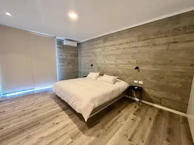 a bedroom with a bed with a wooden wall at 2BR Spacious Ground Level with Gym Pool and Cowork in Paracas