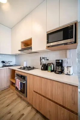 a kitchen with a stove and a microwave at 2BR Spacious Ground Level with Gym Pool and Cowork in Paracas
