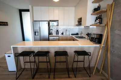 a kitchen with a counter with four stools around it at Aldea 2BR Ocean View Luxury for 4ppl or 2 couples in Paracas