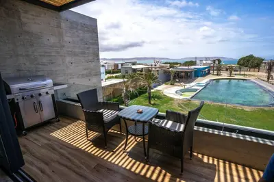 a balcony with a table and chairs and a pool at Aldea 2BR Ocean View Luxury for 4ppl or 2 couples in Paracas