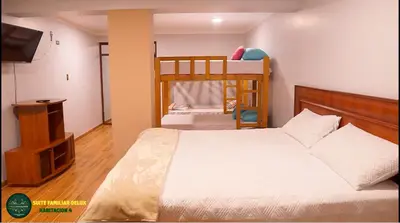 a bedroom with two bunk beds and a television at Villa San Ramon - BIG HOUSE - Chamchamayo in San Ramón