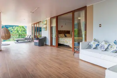 a living room with a white couch and a bed at Villa San Ramon - BIG HOUSE - Chamchamayo in San Ramón