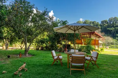 a table and chairs with an umbrella in the grass at Villa San Ramon - BIG HOUSE - Chamchamayo in San Ramón