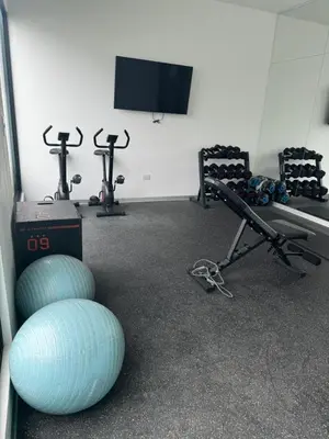 a gym with two exercise bikes and a flat screen tv at Cómodo y Acogedor Departamento Cerca de Barranco y el Circuito de Playas in Lima