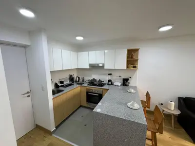 a kitchen with white cabinets and a counter top at Cómodo y Acogedor Departamento Cerca de Barranco y el Circuito de Playas in Lima
