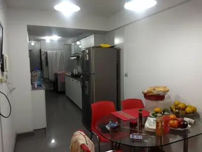 a small kitchen with a table and a refrigerator at Moderno Apartamento Vista al Parque - San Borja Sur - Lima Perú in Lima