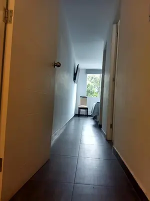 a hallway with a door and a table in a room at Moderno Apartamento Vista al Parque - San Borja Sur - Lima Perú in Lima