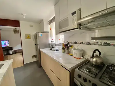 a kitchen with a stove and a refrigerator at Cerca a las universidades San Marcos y Católica in Lima
