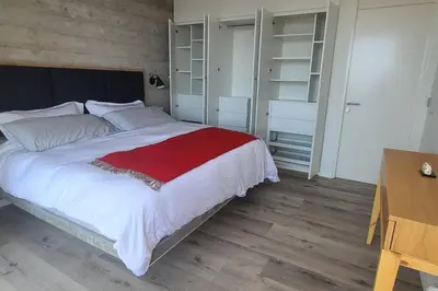 a bedroom with a large bed and a wooden floor at Aldea 1BR Penthouse wtih Private Pool and Views for 2 in Paracas