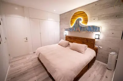 a bedroom with a large bed with a wooden wall at Aldea 1BR Bohemian Rooftop Ocean View for 2 in Paracas