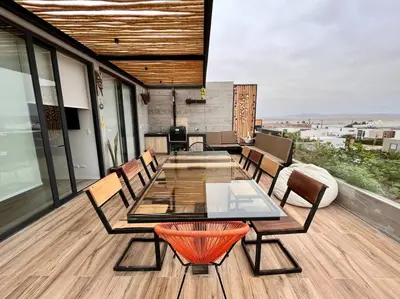 a dining room with a table and chairs on a balcony at Aldea 1BR Bohemian Rooftop Ocean View for 2 in Paracas