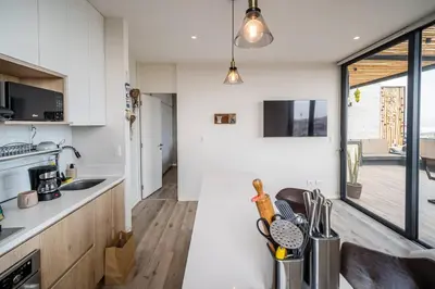 a kitchen with white walls and a large window at Aldea 1BR Bohemian Rooftop Ocean View for 2 in Paracas