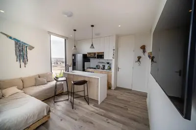a room with a bed and a kitchen with a couch at Aldea 1BR Bohemian Rooftop Ocean View for 2 in Paracas