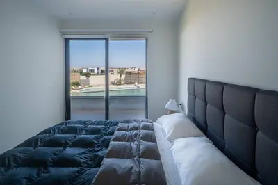 a bed in a room with a large window at Aldea 2BR Boho Style for 4 with Gym, Pool and Cowork in Paracas